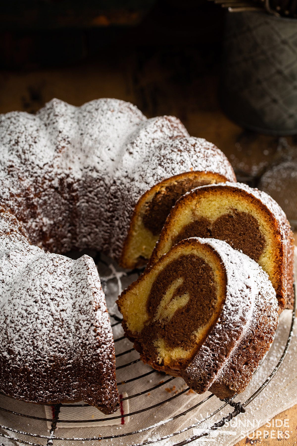 Sliced marble cake with powdered sugar on top.