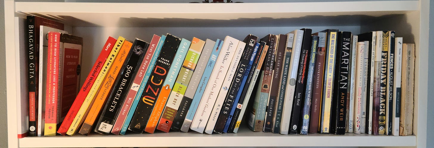 a shelf of an assortment of books. some are tipped over due to several empty spaces