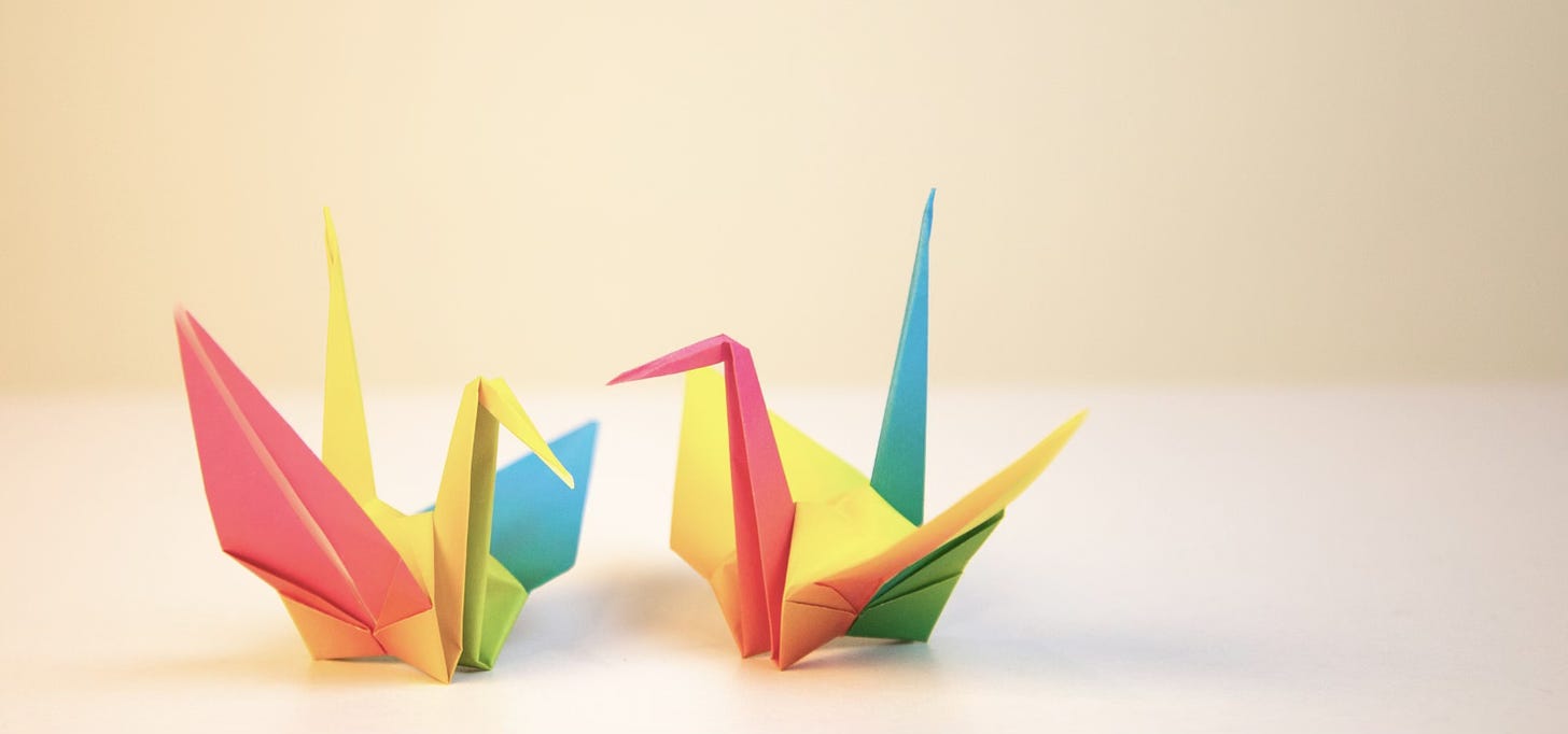 Two origami cranes talking