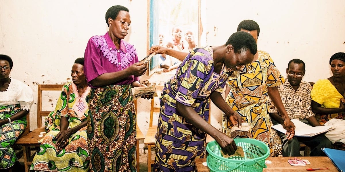 Burundian women and men in national dress collecting money from savings club members