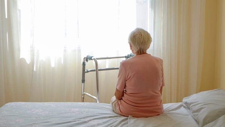 Elderly woman in nursing home room.