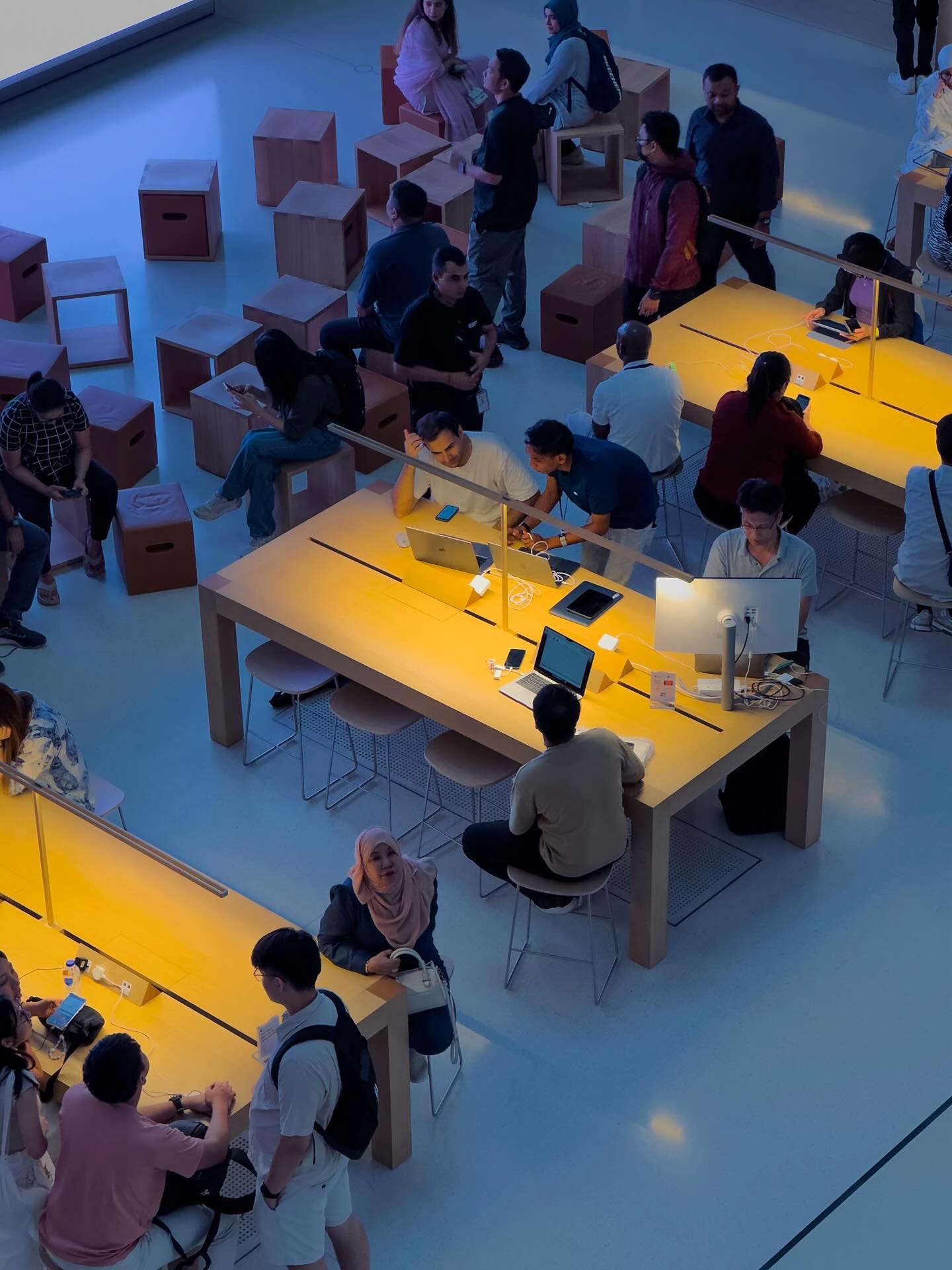 Customers sit at tables on the Forum level of Apple The Exchange TRX.