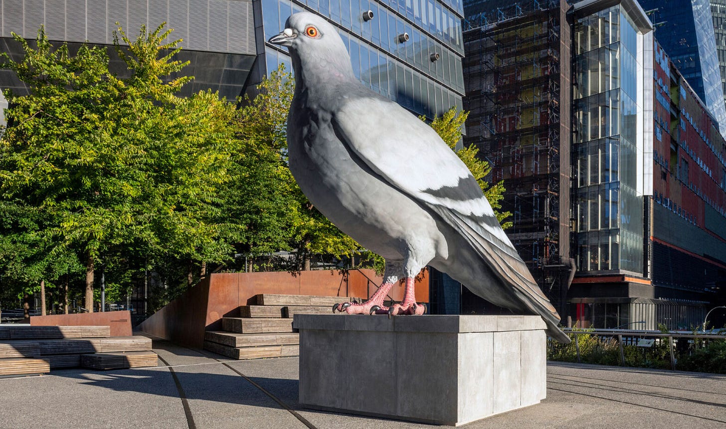 Giant pigeon sculpture in front of a building and trees