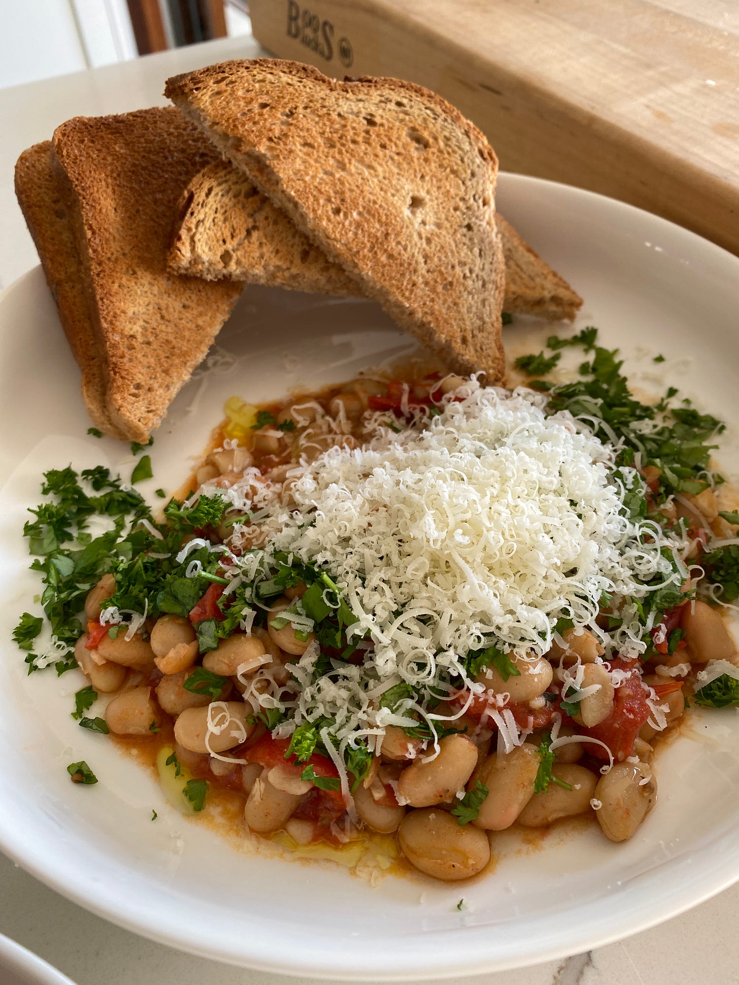 brothy beans with tomato, herbs, parmesan, and toast