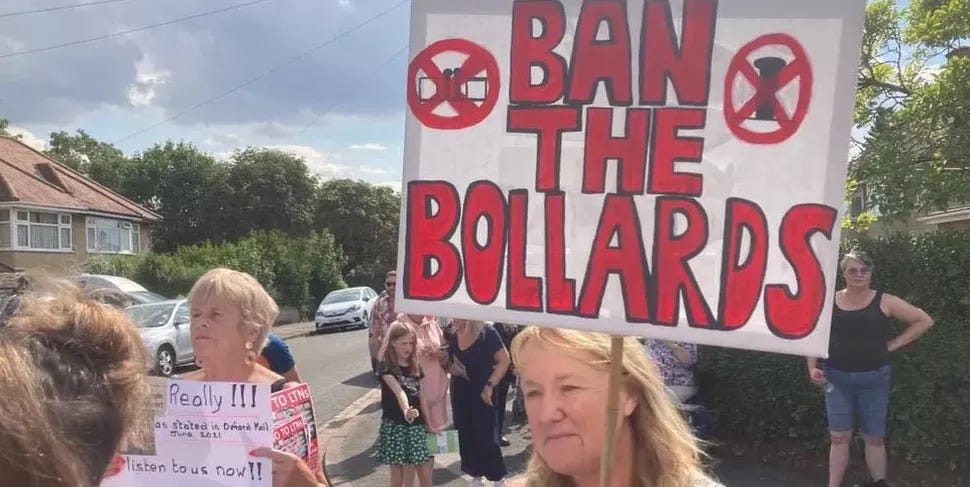 A picture of local residents one holding a sign that says 'ban the bollards'