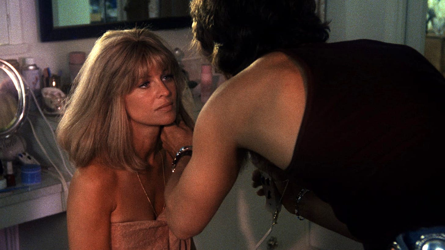 Screen grab from the Hal Ashby film 'Shampoo'. Julie Christie's character looking at Warren Beatty's who's doing her hair.