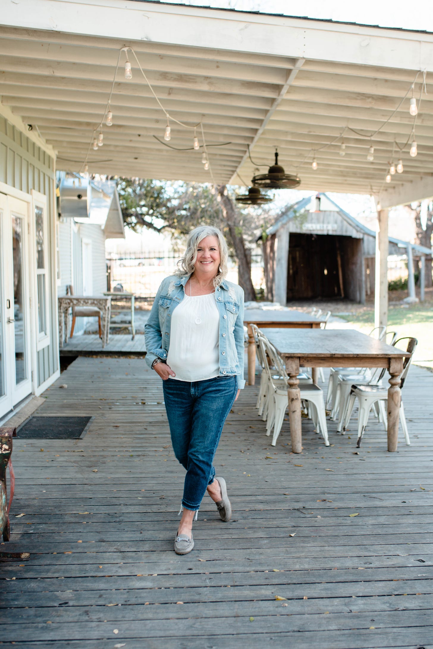 Christi Flaherty on her porch with tables behind her.