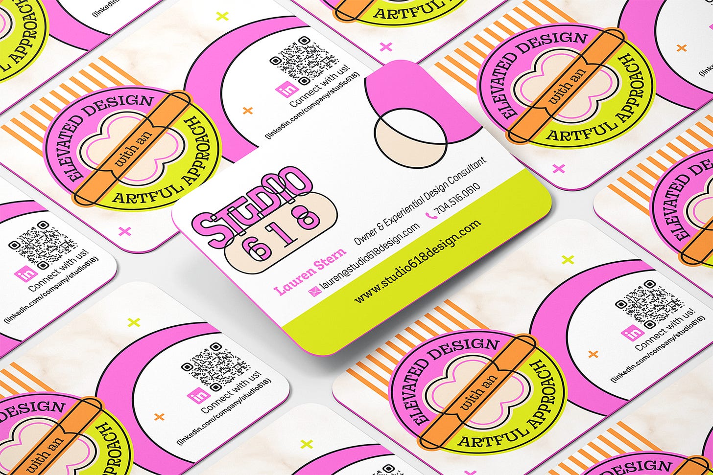 A mockup showcasing Studio 618's business card design. The cards are displayed in a layered, overlapping arrangement, highlighting both the front and back sides of the design. The business cards feature the following elements: Front Side: The "Studio 618" logo is prominently placed at the top in a full-color version, with "Studio" in pink and "618" in beige within a rounded rectangle. Below the logo, the card includes the name "Lauren Stern" in pink, followed by the title "Owner & Experiential Design Consultant." Contact information is provided in a clean, modern layout, including an email address, a phone number, and the website URL (www.studio618design.com). The card's background features bright, contrasting colors with a lime green stripe at the bottom and abstract graphic elements in pink, beige, and orange. Back Side: The back of the card emphasizes a circular badge design with the tagline "Elevated Design with an Artful Approach" encircling a central graphic element resembling a flower or cloud. A QR code for LinkedIn is included, encouraging connections with a call-to-action "Connect with Us!" and the LinkedIn URL. The background of the back side includes additional abstract shapes and lines, consistent with the front's color scheme and design elements. The business cards have rounded corners, giving them a modern and approachable look that aligns with the playful yet professional branding of Studio 618.