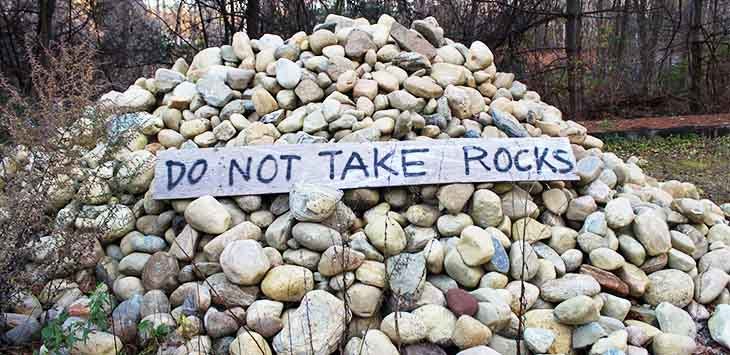 Photo of a pile of rocks with a handwritten sign on them to say "Do not take rocks".