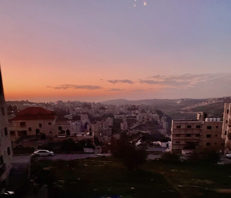 View from Ramallah hotel with a pink sky cascading over the city.