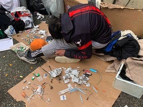 An drug user slumps in a back lane in Vancouver.