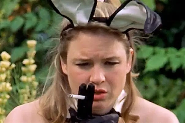 Bridget Jones, a white woman with long blonde hair, in a bunny costume. She's smoking a cigarette with a concerned expression on her face.