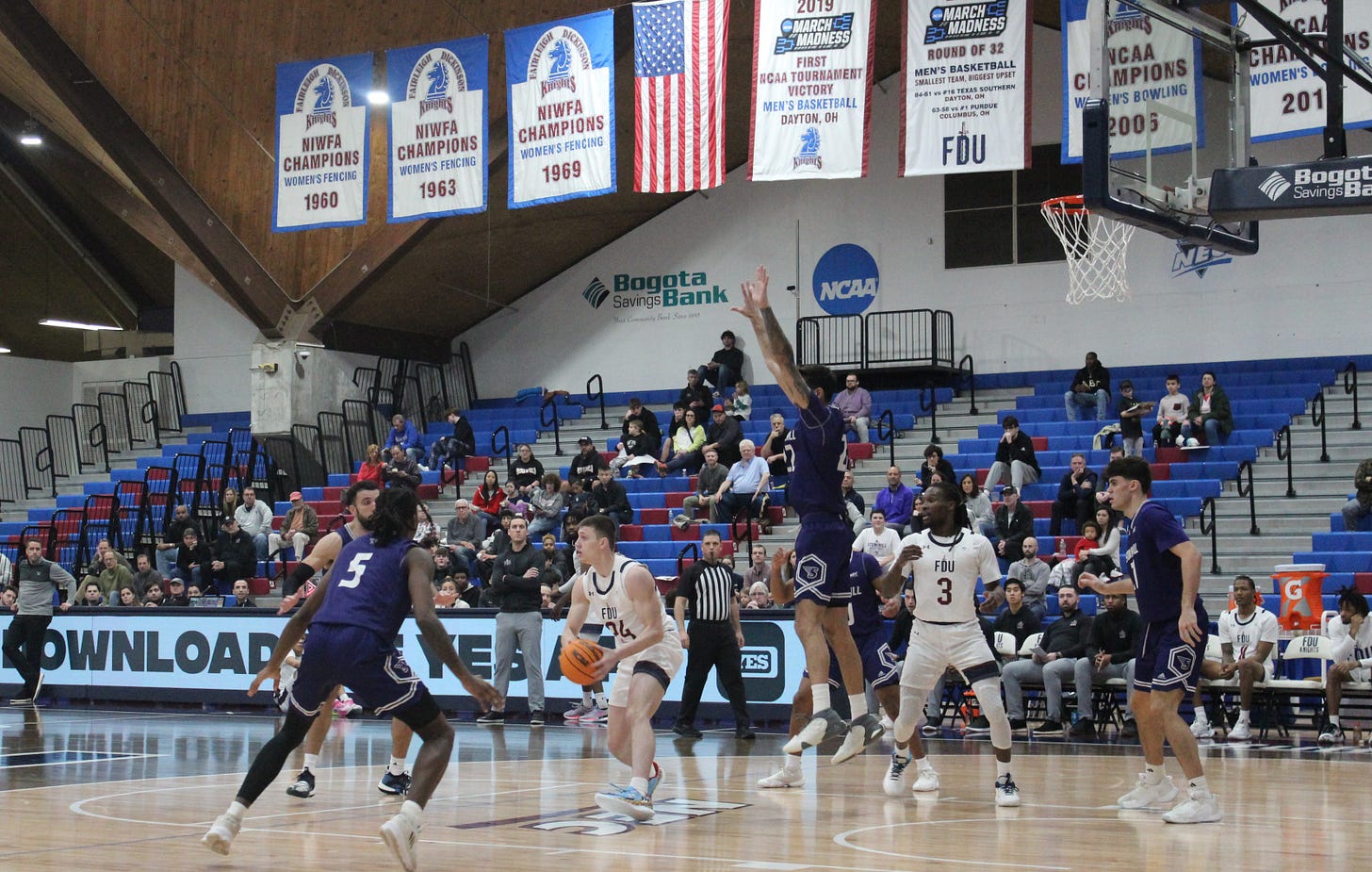 Brayden Reynolds (center, with ball) looks to pass during FDU’s 81-74 overtime victory over Stonehill on Jan. 14, 2024. (Photo by Adam Zielonka)