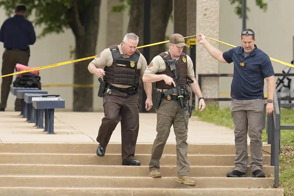 Oklahoma state troopers walk under police tape following a fatal shooting at Rose State College in Midwest City, Okla., on Monday, April 24, 2023. Police said a suspect is in custody after school officials told students to shelter in place. (AP Photo/Sue Ogrocki)