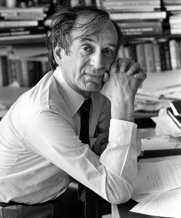 Elie Wiesel in 1985 sitting in his office with papers strewn about his desk