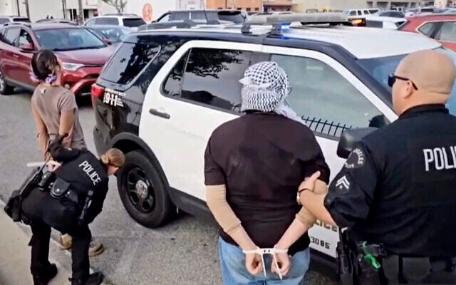 This video still image provided by KABC-TV shows protesters being arrested by Los Angeles police officers on Wednesday, Dec. 27, 2023, near Los Angeles International Airport. Pro-Palestinian, anti-Israel protesters briefly blocked entrance roads to airports in New York and Los Angeles, forcing some travelers to set off on foot to bypass the jammed roadway. (KABC-TV via AP)