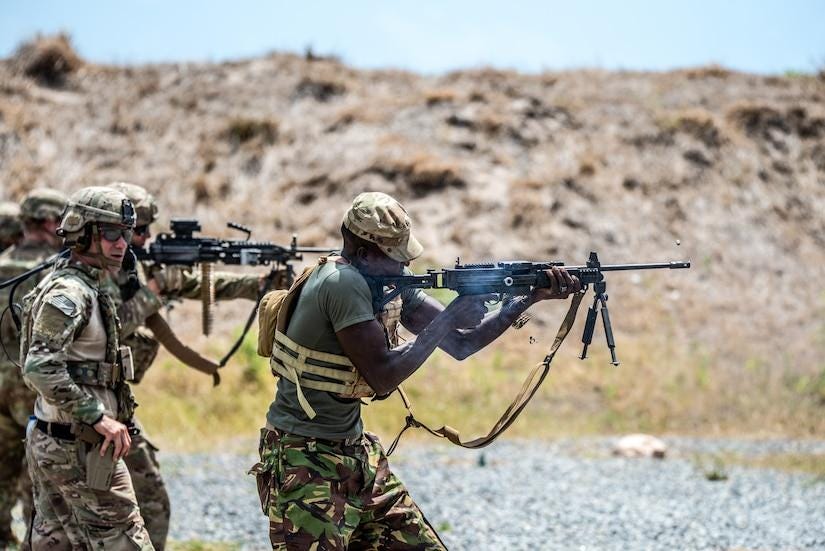 Uniformed personnel fire rifles.