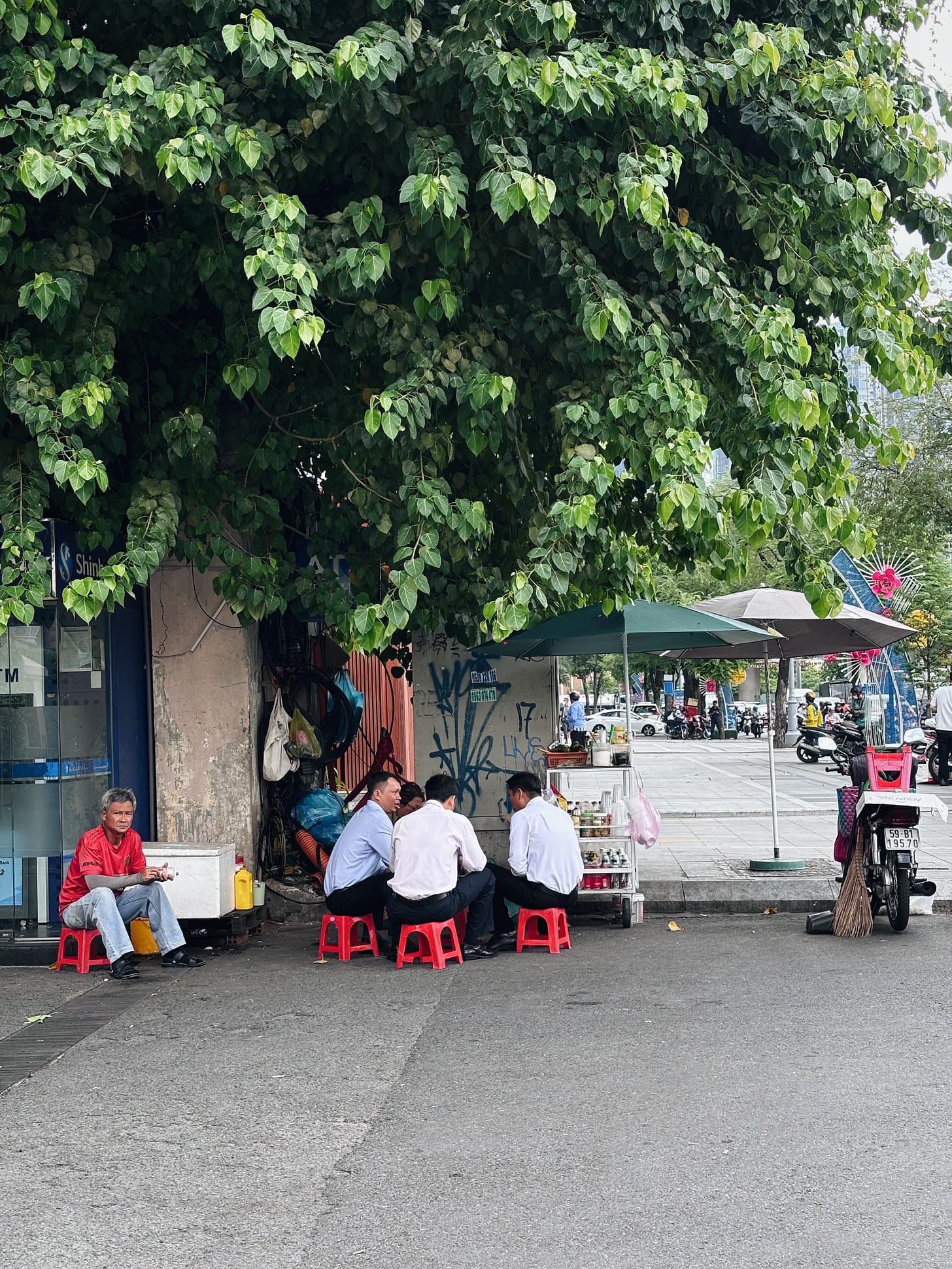 Men eating on plastic stools in Vietnam