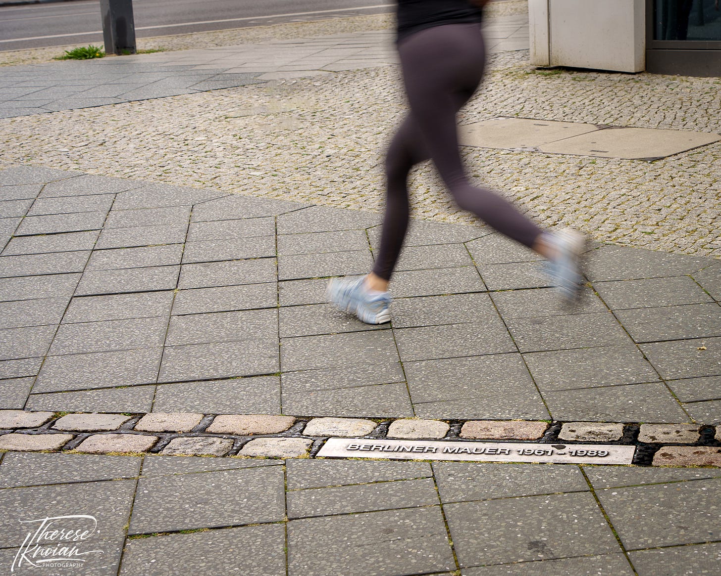 Blurred legs from a runner running along the Berlin Wall in Berlin