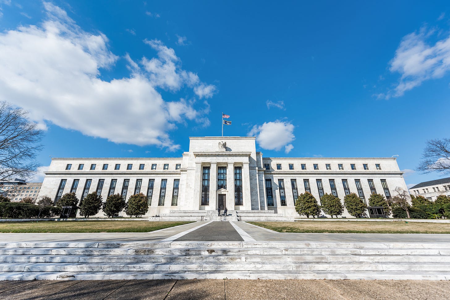 Washington DC, USA: Federal Reserve bank entrance wide angle architecture building wall security guard doors, path, american flags, blue sky Washington DC, USA: Federal Reserve bank entrance wide angle architecture building wall security guard doors, path, american flags, blue sky