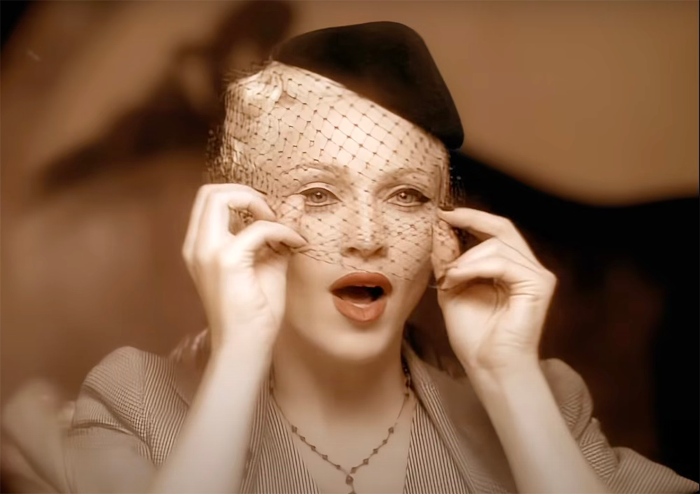 Madonna in the Take A Bow video  drawing a veil over her face