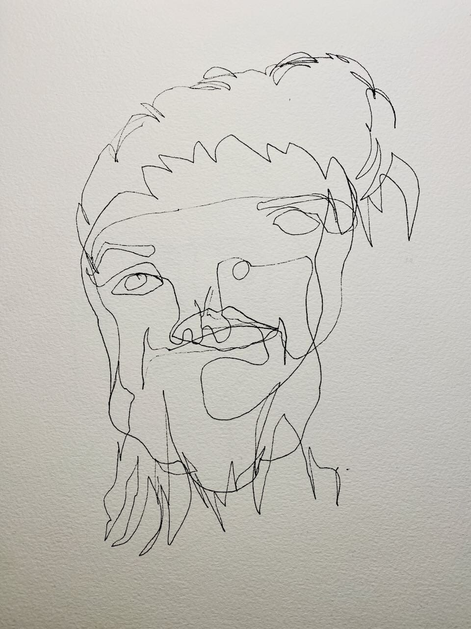 Blind contour self-portrait. The eyes are in odd places and the mouth is drawn over the nose, but something of the character comes through. 