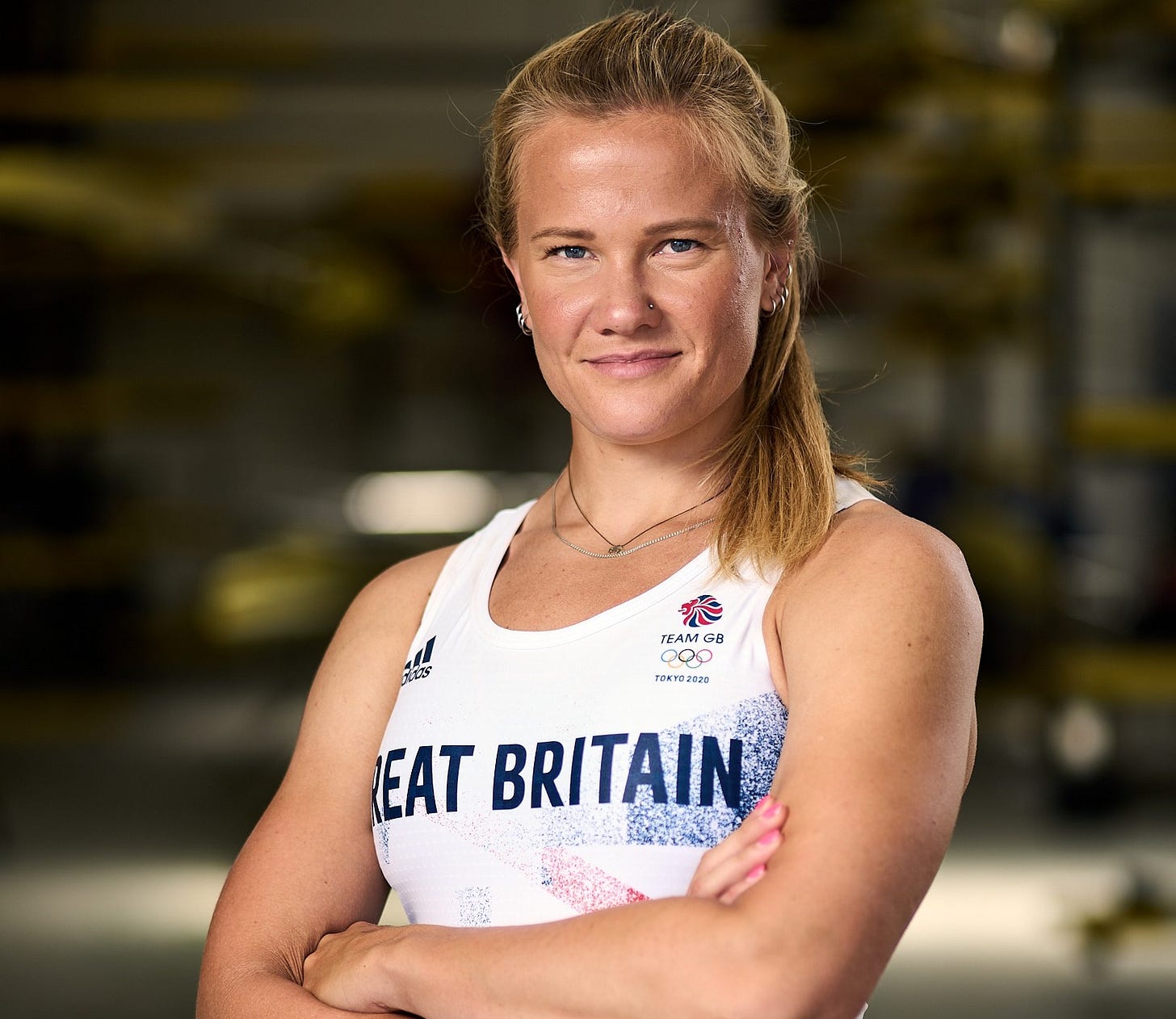 Caragh standing with her arms crossed in front of her, wearing her Great Britain OLY outfit and smiling.