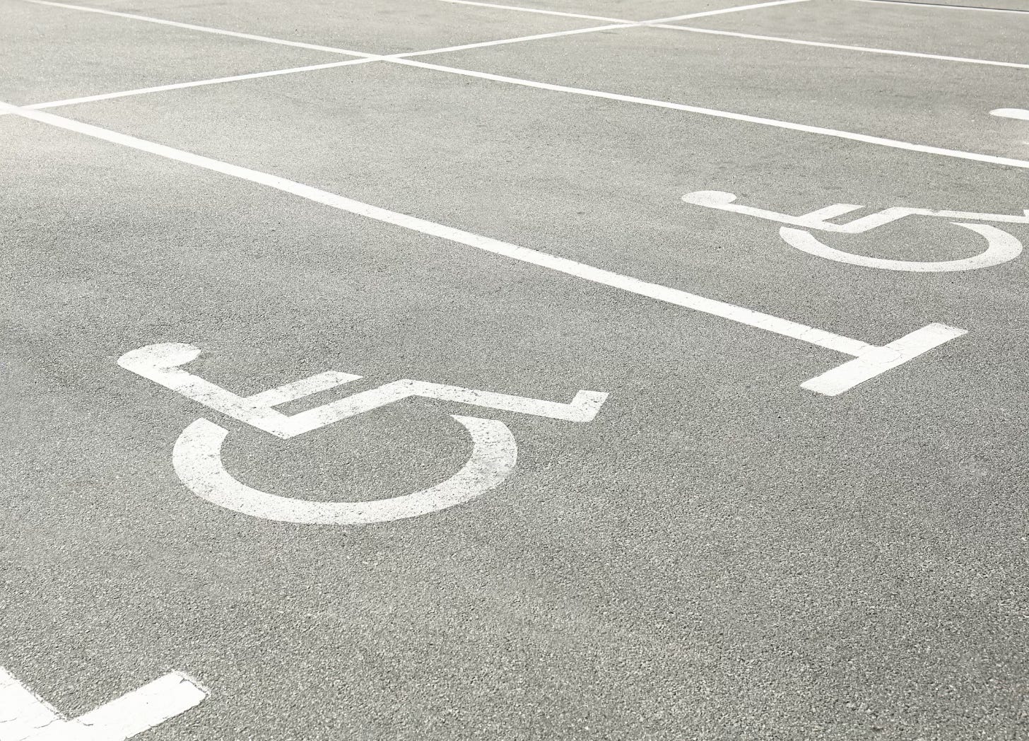 Accessible parking spaces marked on pavement with wheelchair symbols