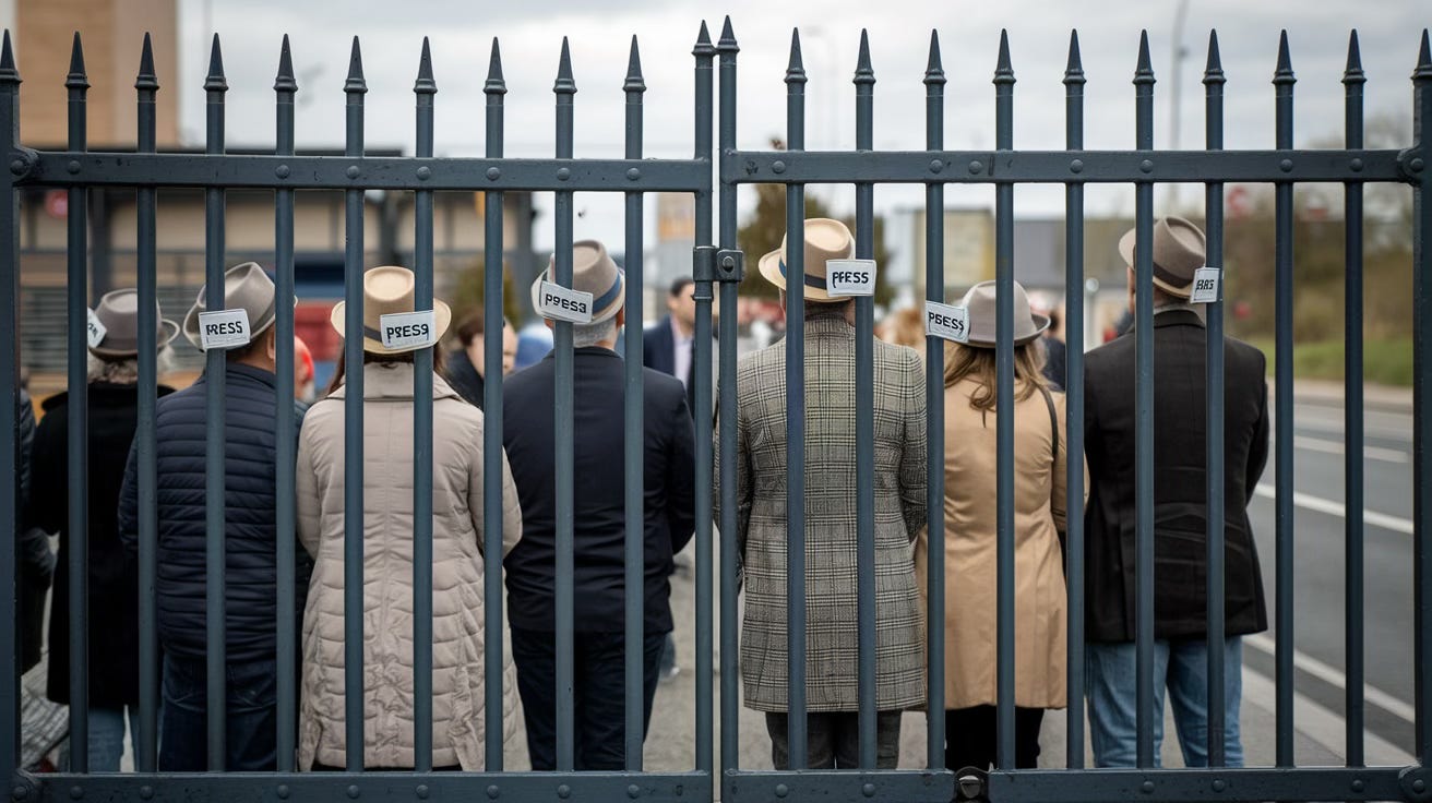 A group of journalists standing in front of a set of gates preventing anyone getting past