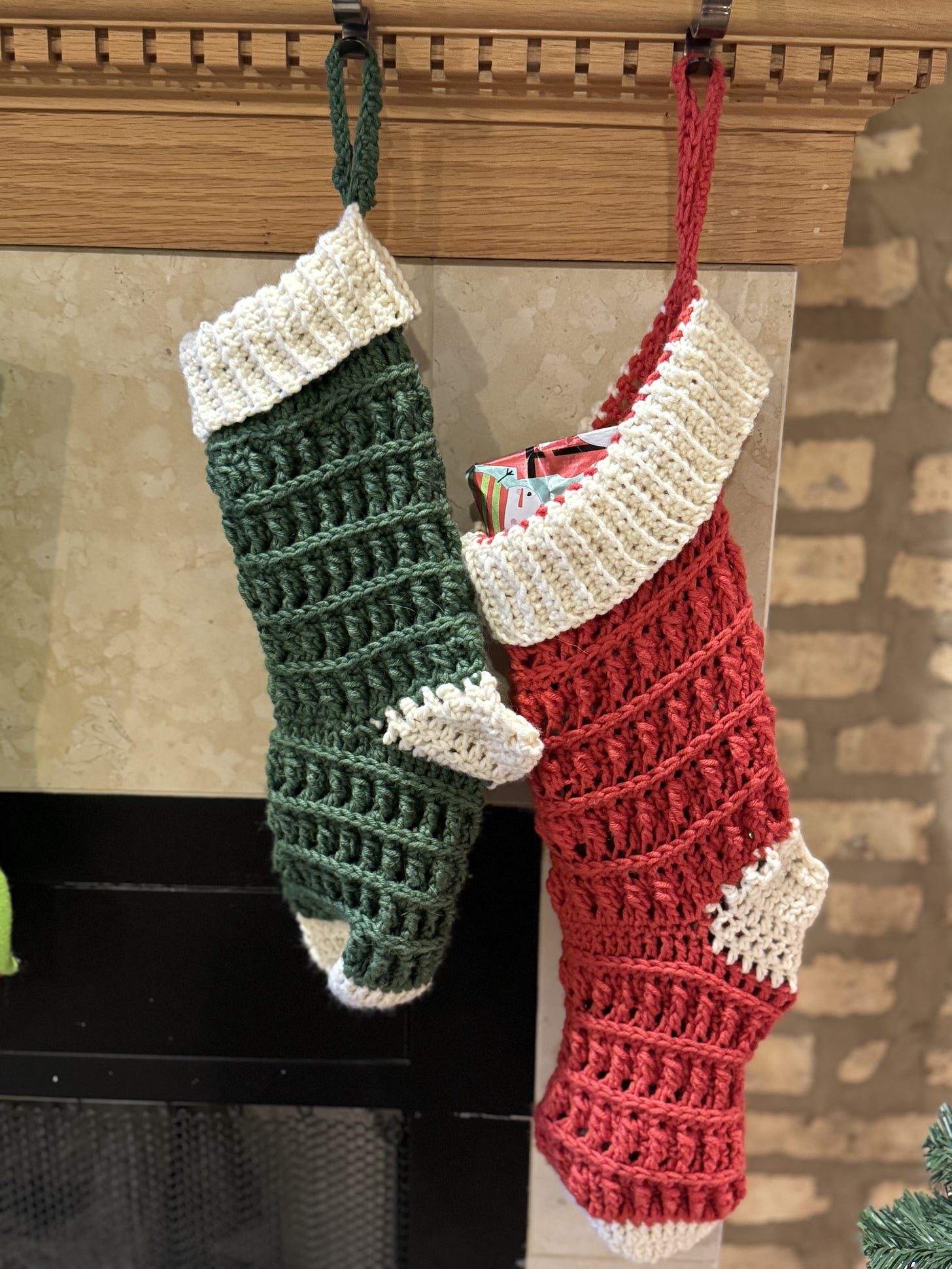 Two crocheted Christmas stockings, one green, one red.