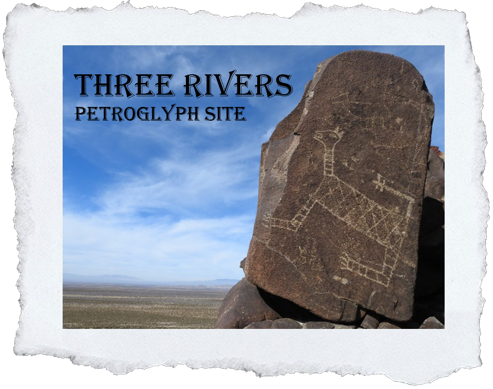 Photo of a cat-like petroglyph on a rectangular block of stone.  In the background is a wide, flat valley and a broad blue sky with wispy clouds.