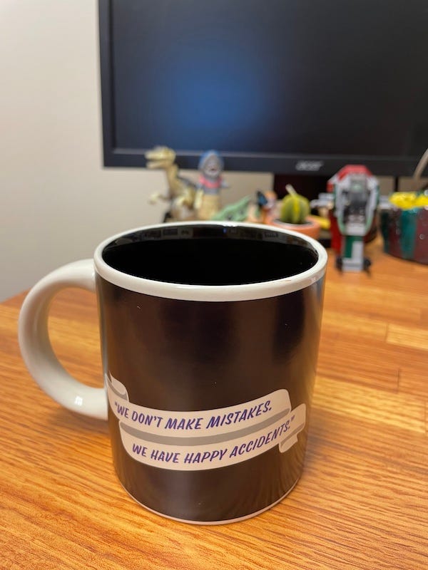 A mug with Bob Ross's catchphrase: "We don't make mistakes; we have happy accidents."