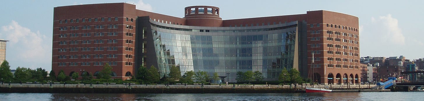 A large brick building viewed from across a body of water