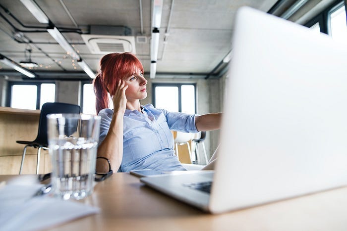 A woman looking sad sitting in front of a laptop A woman looking sad sitting in front of a laptop