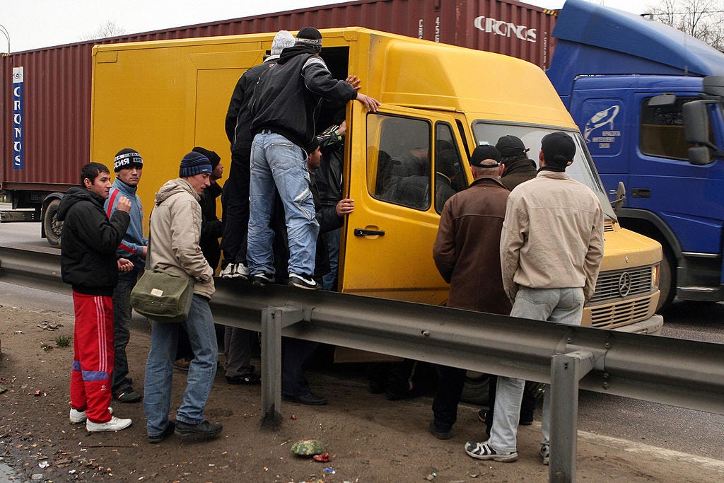 Tajik migrant workers getting into a truck in the outskirts of Moscow, October, 2008