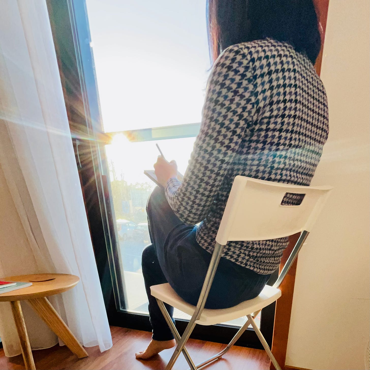 image: a lady sitting on a chair, facing the window, painting, The sun ray is bursting through the window. photo by melinda yeoh