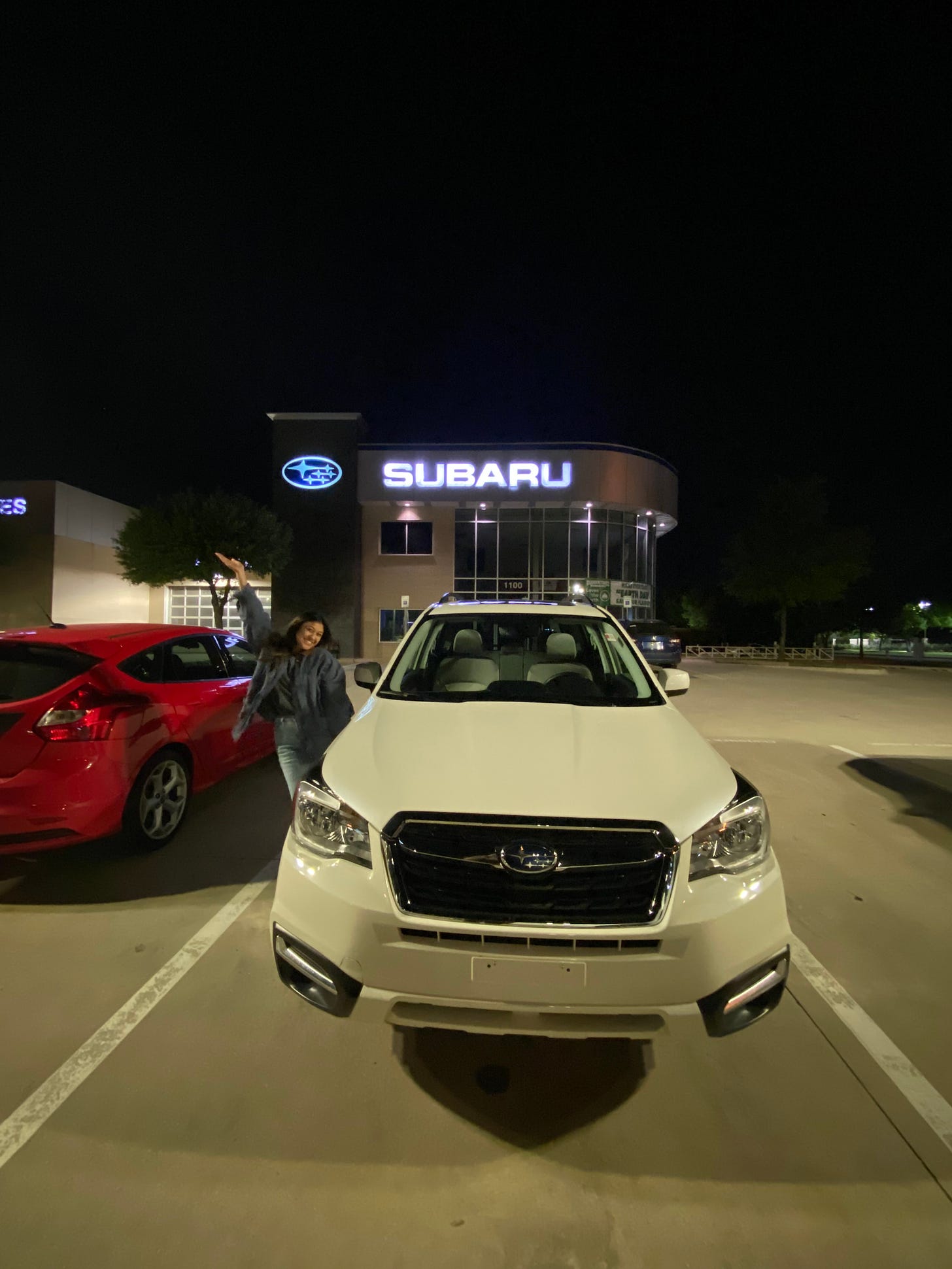 Sam poses next to her Subaru at the dealership
