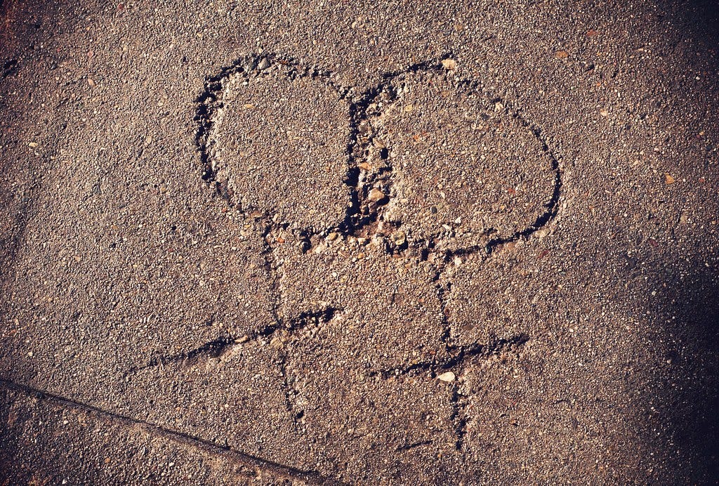 two female symbols intertwined in a dried carving on a sidewalk