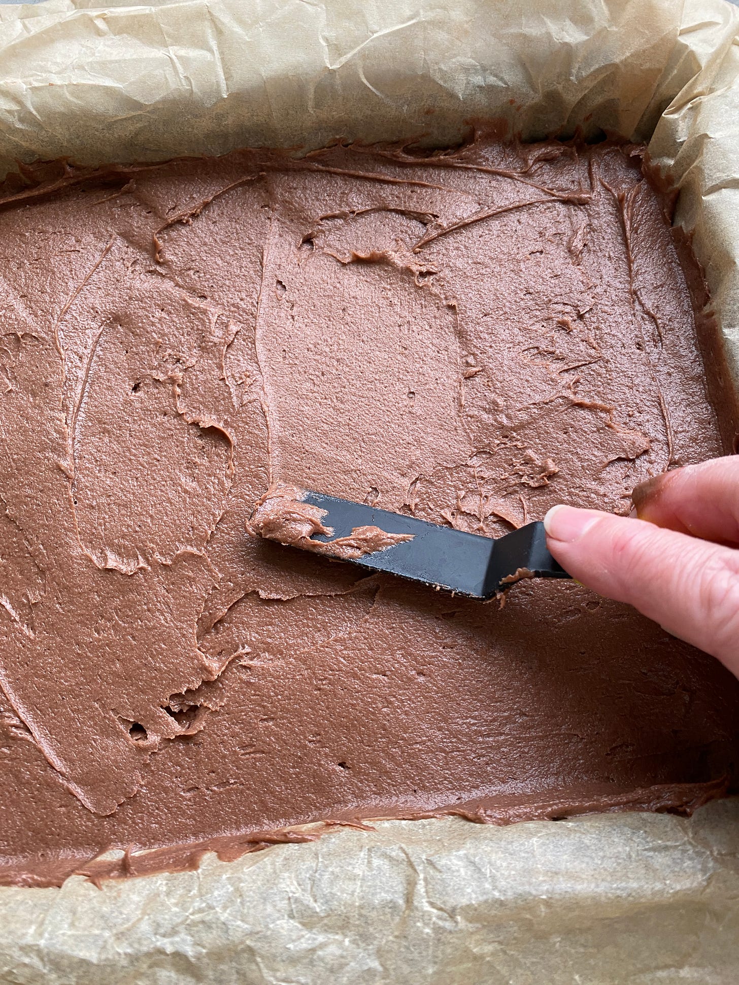 Chocolate sponge traybake before and after baking. 