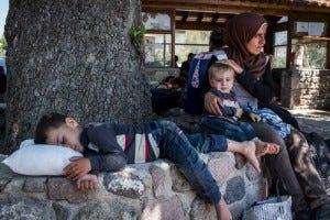 A refugee mother and her two children rest after arriving by boat on the island of Lesvos. A refugee mother and her two children rest after arriving by boat on the island of Lesvos.