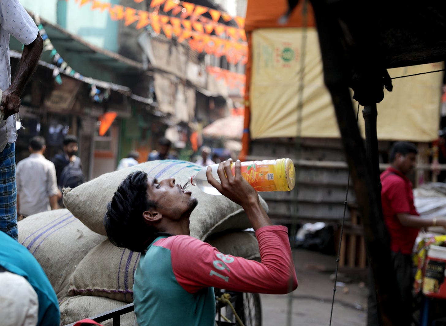 An Indian labourer drinks water during hot midday sun at Burabazar in Kolkata, eastern India