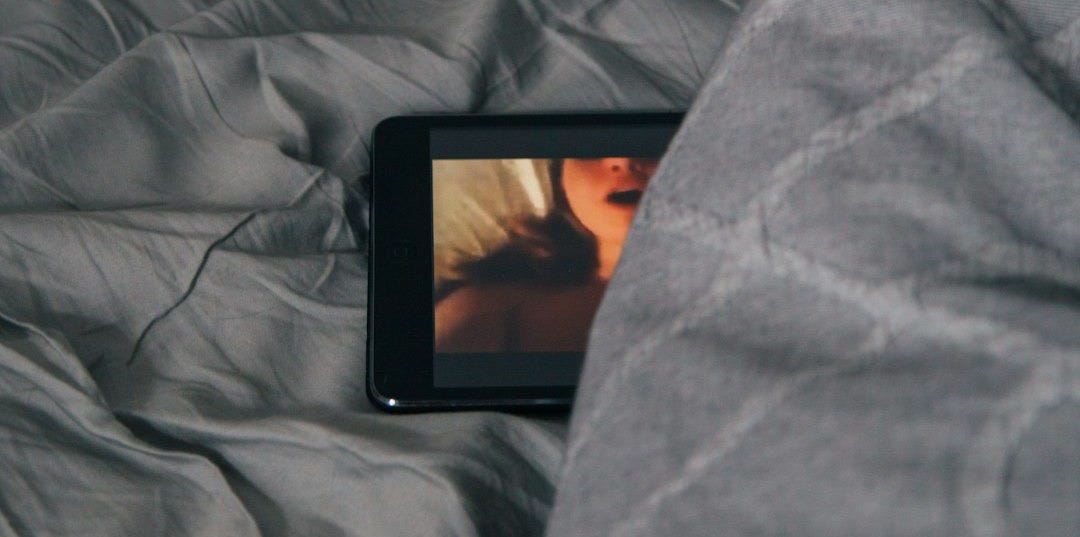 black Android smartphone on gray bed sheet