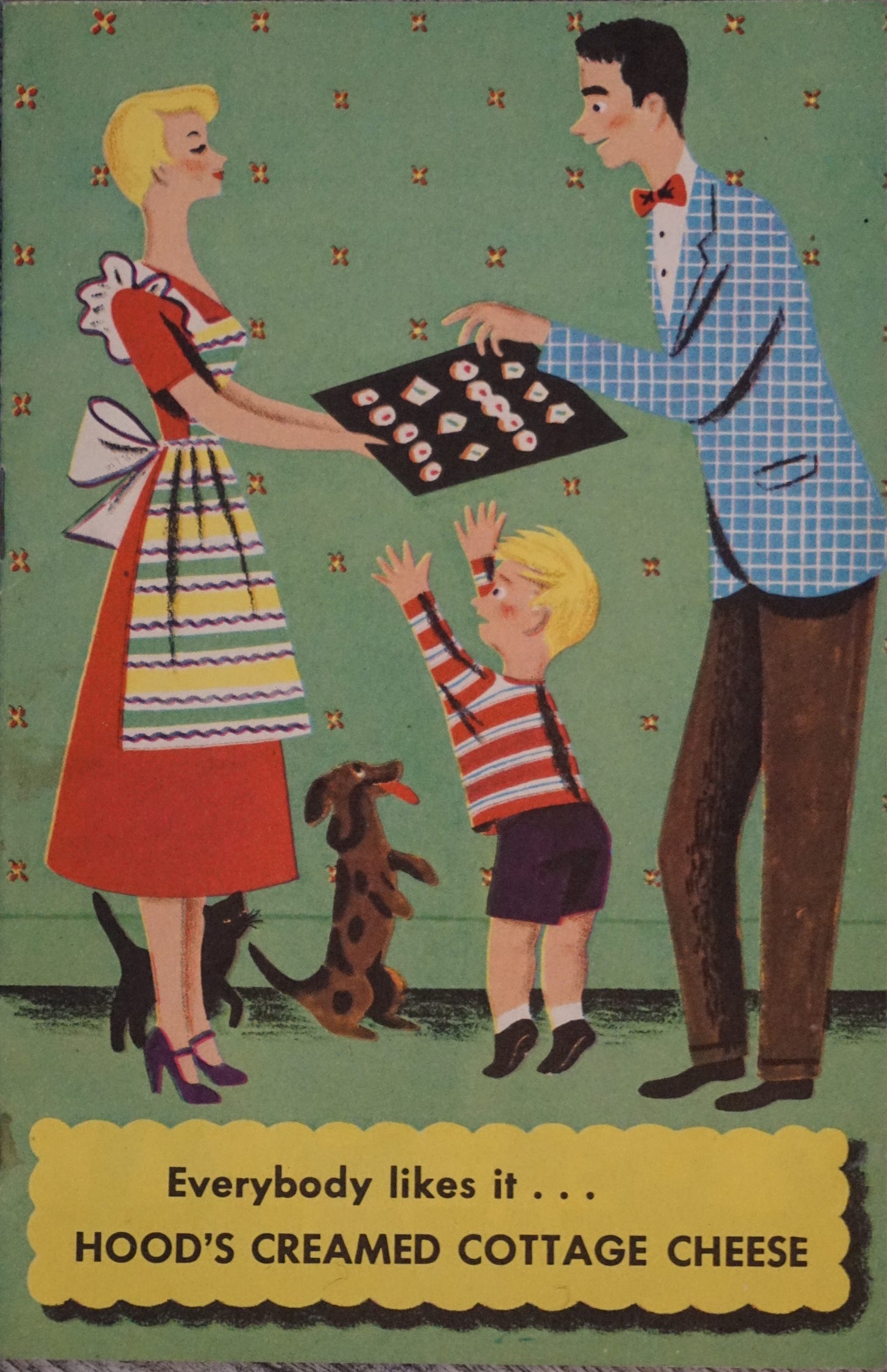 Photo of the cover of a promotional pamphlet for Hood's Creamed Cottage Cheese, which has the words "everybody likes it..." before the title. It shows a retro (60s?) drawing of a housewife in a red dress and apron holding out a tray of...something. Cookies? for her husband and son. And dog and cat, maybe. They're there too.