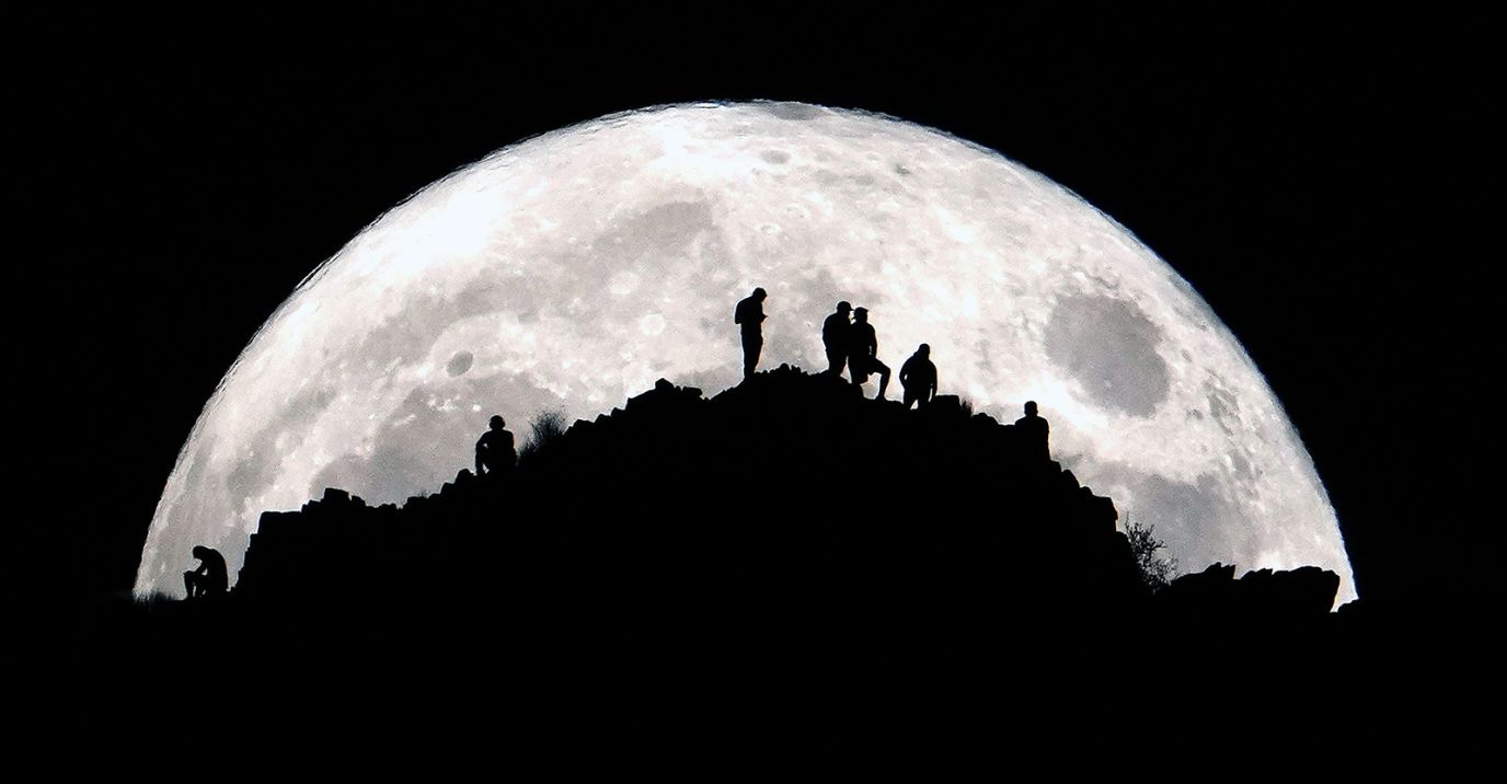 Hikers watch the super blue moon from the summit of Piestewa Peak in Phoenix, US, on August 30.