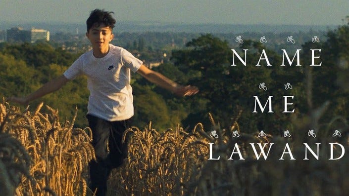 A young Kurdish boy is running through a field of dry grass with a lush green landscape behind him in the distance. A title says NAME ME LAWAND.