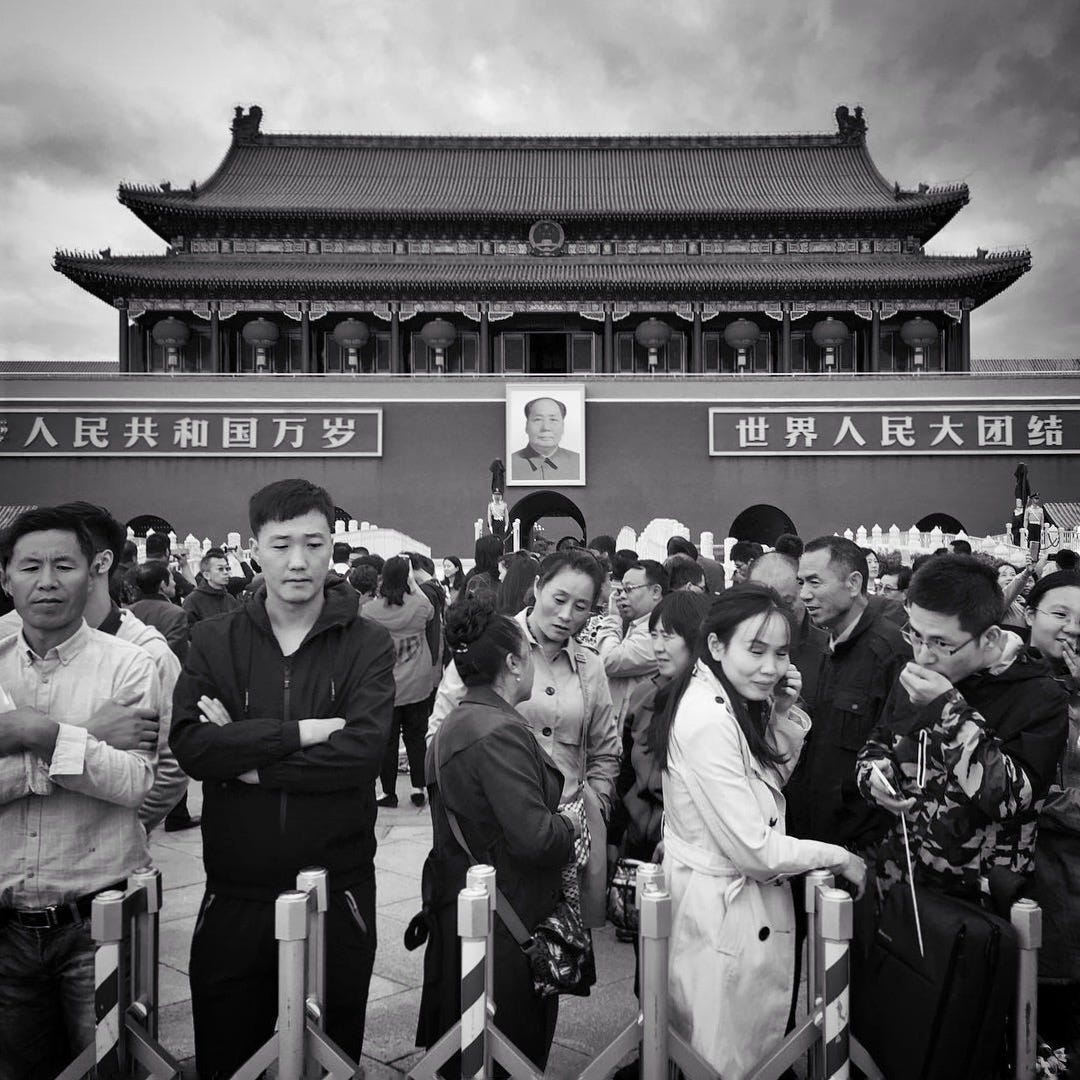 Tourists pose for photos in front of the iconic Mao portrait at the Tiananmen Gate, Beijing.