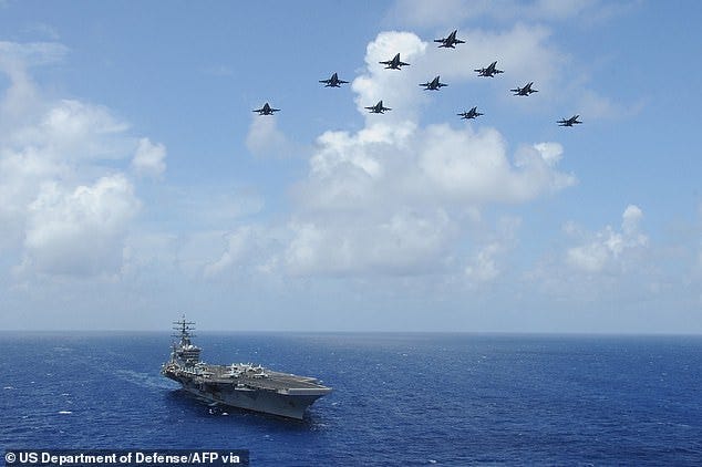 F/A-18C Hornets assigned to the Wildcats of Strike Fighter Squadron (VFA) 131 fly over the aircraft carrier USS Dwight D. Eisenhower. The Hornets were in action on Tuesday to shoot down missiles fired from Yemen into the Red Sea