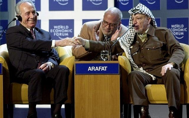 Yasser Arafat shakes hands with Shimon Peres at the World Economic Forum in Davos, 2001 (photo credit: CC BY-SA World Economic Forum)