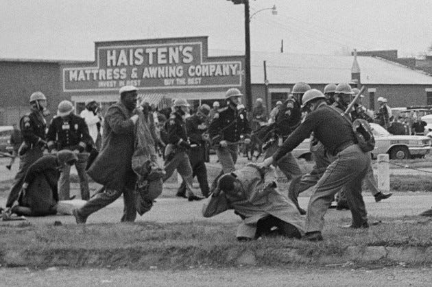 John Lewis (foreground) is beaten by a state trooper during a voting rights march in Selma, Ala., on March 7, 1965. Lewis suffered a fractured skull.