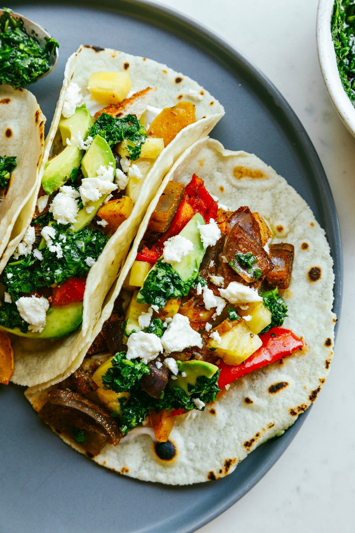 Close up of chimichurri chicken tacos assembled on a plate.